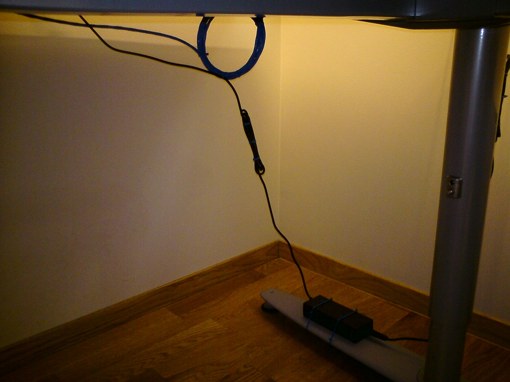 Power cable running under a desk near a home office work area